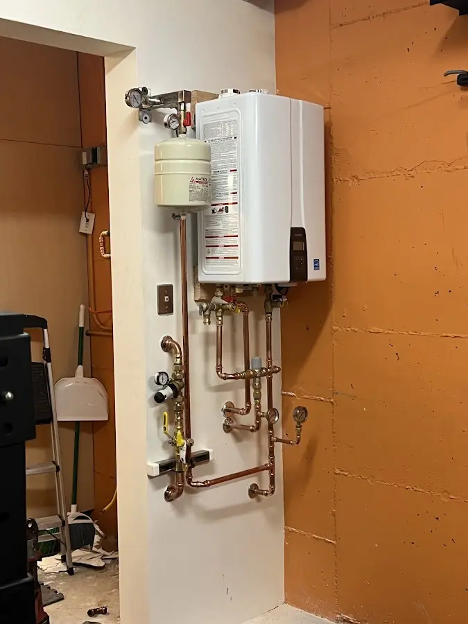 Plumbing technician inspecting water heater connections in Cottonwood
